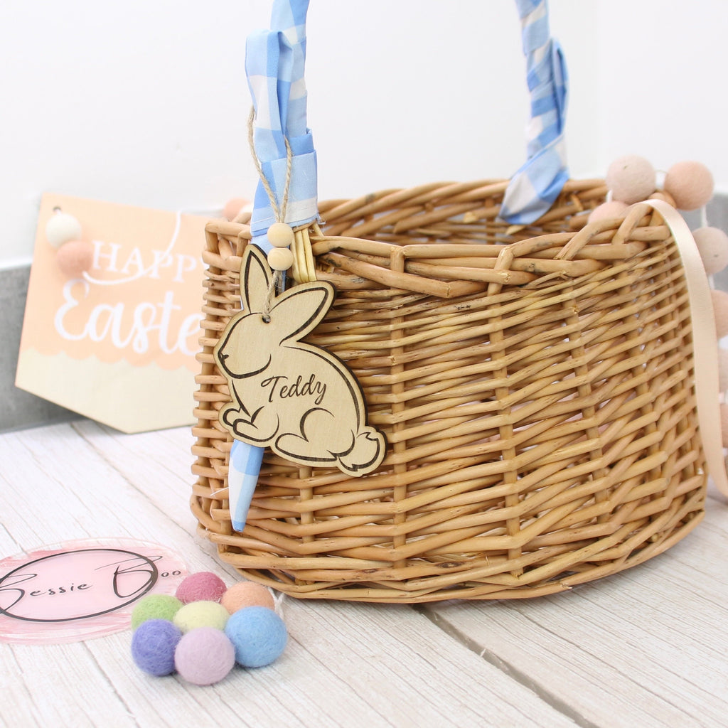 Easter basket wooden tag to be used as an Easter Decoration. The 8cm tag is in the shape of a bunny cut from 3mm Plywood. The item can include personalised text, such as the name of a child. In the image the tag is shown attached to a wicker basket.